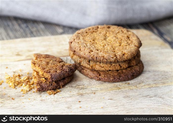 Delicious fresh crunchy oatmeal cookies, one of the biscuits on the broken crumbled. colored cookies