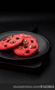 Delicious fresh crunchy pink oatmeal cookies with raspberry flavor on a dark concrete background