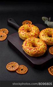 Delicious fresh donuts in yellow glaze with lemon flavor filling on textured concrete background