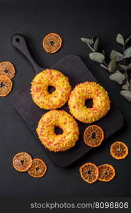 Delicious fresh donuts in yellow glaze with lemon flavor filling on textured concrete background