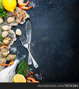 Delicious fresh fish and seafood on dark vintage background. Fish, clams and shrimps with aromatic herbs, spices and vegetables - healthy food, diet or cooking concept