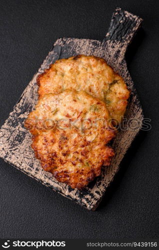 Delicious fresh fried minced chicken meat cutlets with salt, spices and herbs on a dark concrete background