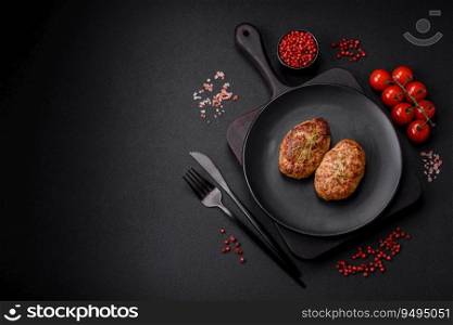 Delicious fresh fried minced fish cutlets with spices and herbs on a dark concrete background