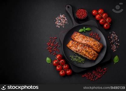 Delicious fresh grilled red fish with salt, spices and herbs on a dark concrete background