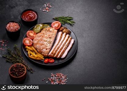 Delicious fresh grilled turkey meat steak with spices and herbs on a dark concrete background