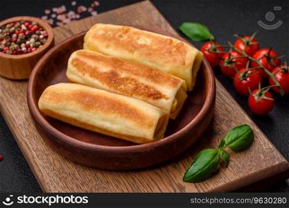 Delicious fresh homemade fried pancakes with broccoli and meat or fish with salt and spices on a dark concrete background