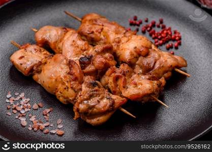 Delicious fresh, juicy chicken or pork kebab on skewers with salt and spices on a dark concrete background