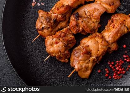 Delicious fresh, juicy chicken or pork kebab on skewers with salt and spices on a dark concrete background