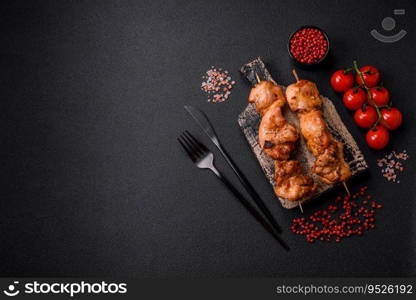 Delicious fresh, juicy chicken or pork kebab on skewers with salt and spices on a dark concrete background