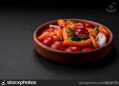 Delicious fresh juicy salad with radishes, tomatoes, carrots, cucumber, spices and herbs on a dark concrete background