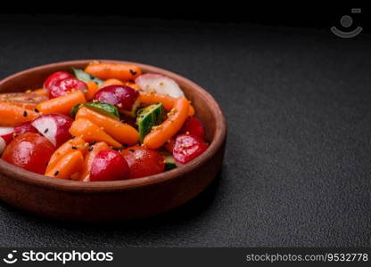 Delicious fresh juicy salad with radishes, tomatoes, carrots, cucumber, spices and herbs on a dark concrete background