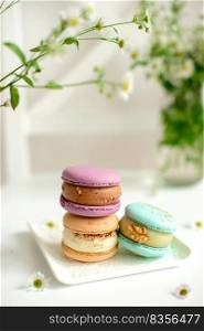Delicious fresh macaroons with filling on a light wooden background. Sweet dessert for coffee. Delicious fresh macaroons with filling on a light wooden background