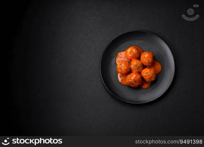 Delicious fresh meatballs in tomato sauce with salt, spices and herbs on a dark concrete background