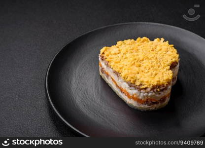 Delicious fresh mimosa salad with canned fish, egg, moinese, cheese, salt and spices on a dark concrete background