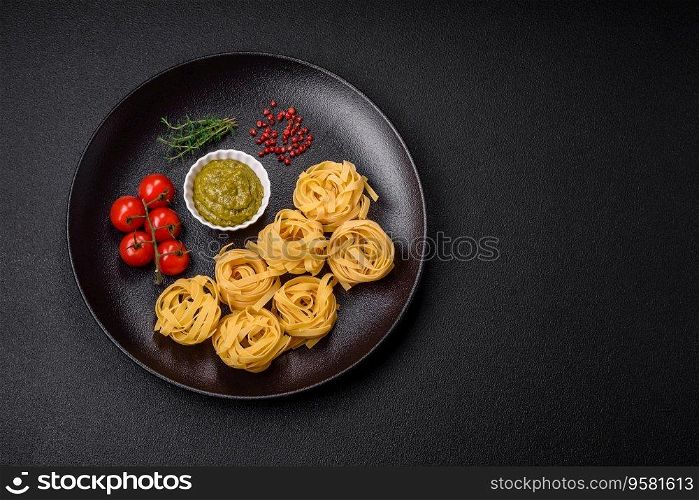 Delicious fresh pasta consisting pesto sauce with salt, spices and herbs on a dark concrete background
