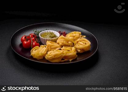 Delicious fresh pasta consisting pesto sauce with salt, spices and herbs on a dark concrete background