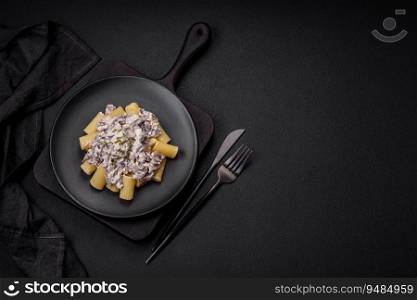 Delicious fresh pasta with ch&ignon mushrooms in a creamy sauce with salt, spices and herbs on a dark concrete background