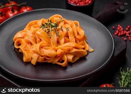  Delicious fresh pasta with pesto sauce, salt, spices and herbs on a ceramic plate on a textured concrete background