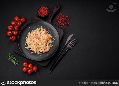 Delicious fresh penna pasta with shrimp, sauce, cheese, salt and spices on a dark concrete background. Delicious fresh penna pasta with shrimp, sauce, cheese, salt and spices