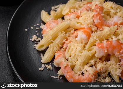 Delicious fresh penna pasta with shrimp, sauce, cheese, salt and spices on a dark concrete background. Delicious fresh penna pasta with shrimp, sauce, cheese, salt and spices
