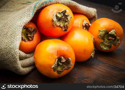 Delicious fresh persimmon fruit on wooden table