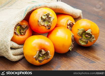 Delicious fresh persimmon fruit on wooden table