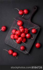 Delicious fresh raw red radish for making healthy salad on dark concrete background
