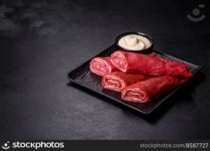 Delicious fresh red pancakes topped with beetroot juice with cheese and eggs on a dark concrete background. Delicious fresh red pancakes topped with beetroot juice with cheese and eggs