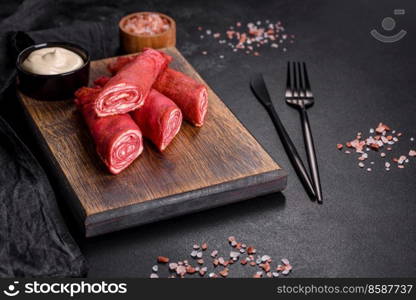 Delicious fresh red pancakes topped with beetroot juice with cheese and eggs on a dark concrete background. Delicious fresh red pancakes topped with beetroot juice with cheese and eggs