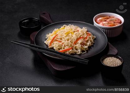 Delicious fresh rice noodles with shrimp, spices and herbs on a dark concrete background. Delicious fresh rice noodles with shrimp, spices and herbs