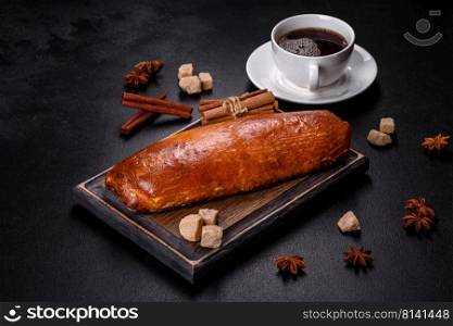 Delicious fresh roll with apricot jam on a dark concrete background. Delicious homemade pastries. Delicious fresh roll with apricot jam on a dark concrete background