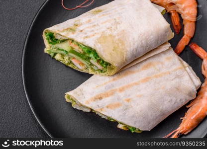 Delicious fresh roll with shrimps, tomatoes, lettuce and cucumber in pita bread on a dark concrete background. Delicious fresh roll with shrimps, tomatoes, lettuce and cucumber in pita bread