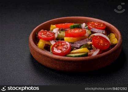 Delicious fresh salad with beef slices, cherry tomatoes, sweet peppers, salt, spices and herbs on a textured concrete background