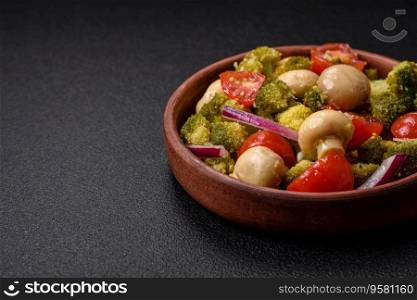 Delicious fresh salad with broccoli, cherry tomatoes, mushrooms, onions, salt, spices and herbs on a dark concrete background