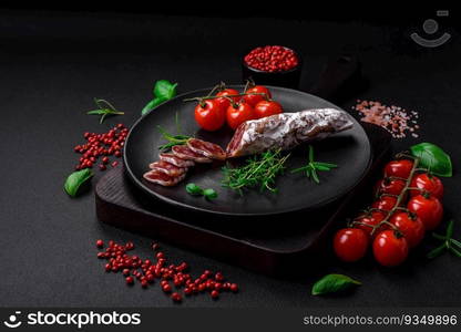 Delicious fresh smoked fuet sausage with salt, spices and herbs on a dark concrete background