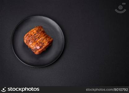 Delicious fresh smoked meat or ham with sπces and herbs on a dark concrete background