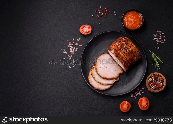 Delicious fresh smoked meat or ham with spices and herbs on a dark concrete background