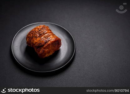 Delicious fresh smoked meat or ham with spices and herbs on a dark concrete background