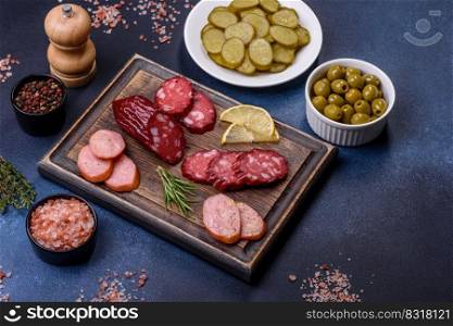 Delicious fresh smoked sausages cut with slices on a wooden cutting board against a dark concrete background. Delicious fresh smoked sausages cut with slices on a wooden cutting board