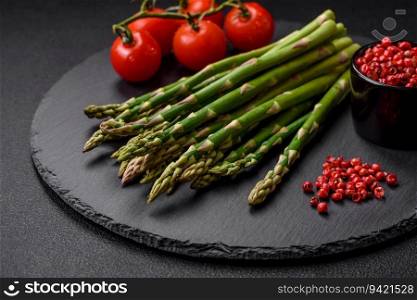 Delicious fresh sprigs of asparagus on a dark textured background. Ingredients for a healthy vegetarian meal