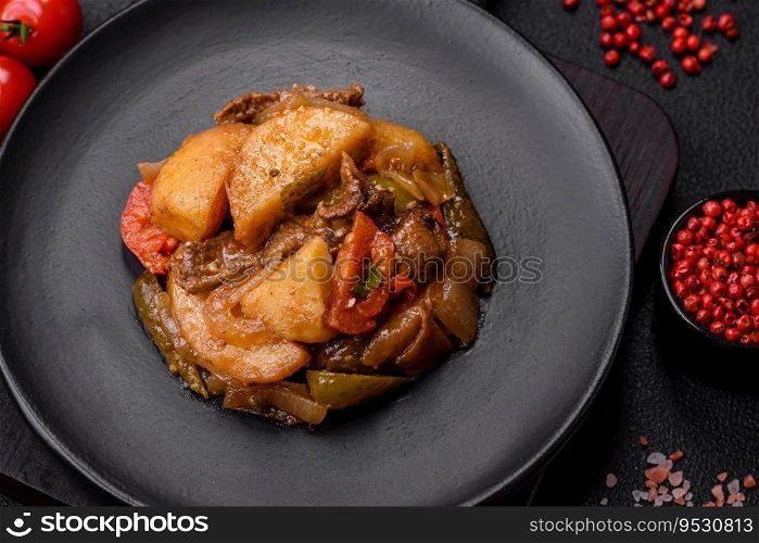 Delicious fresh stew of potatoes, tomatoes, onions, carrots and beef meat with salt, spices and herbs on a dark concrete background