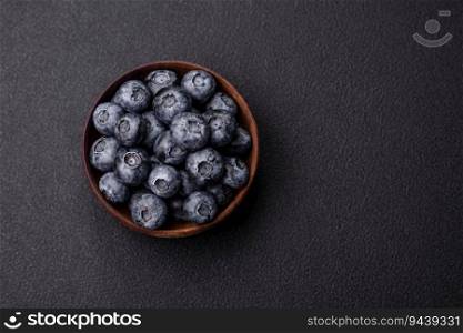 Delicious fresh sweet blueberries in a ceramic bowl on a dark concrete background