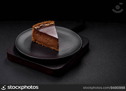 Delicious, fresh, sweet chocolate cake with nuts cut into slices on a dark concrete background