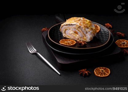 Delicious, fresh, sweet meringue roll with cream, almond chips, nuts and berries cut into slices on a dark concrete background