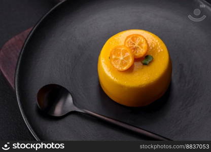 Delicious fresh tartlet with citrus filling and decorated with passion fruit on a black plate