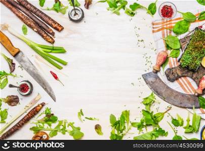 Delicious fresh vegetables, spices and seasoning for tasty cooking with kitchen knife on white wooden background, top view, frame. Healthy clean or vegetarian food concept.