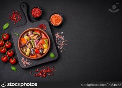 Delicious fresh vegetarian salad with tomatoes, green beans, eggplant, pepper, salt, spices and herbs on a dark concrete background. Delicious fresh vegetarian salad with tomatoes, green beans, eggplant and pepper
