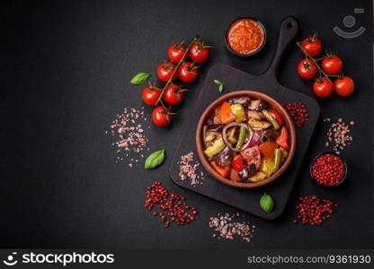 Delicious fresh vegetarian salad with tomatoes, green beans, eggplant, pepper, salt, spices and herbs on a dark concrete background. Delicious fresh vegetarian salad with tomatoes, green beans, eggplant and pepper