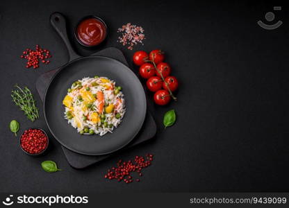 Delicious fresh white boiled rice with vegetables carrots, peppers and asparagus beans on a ceramic plate on a dark concrete background