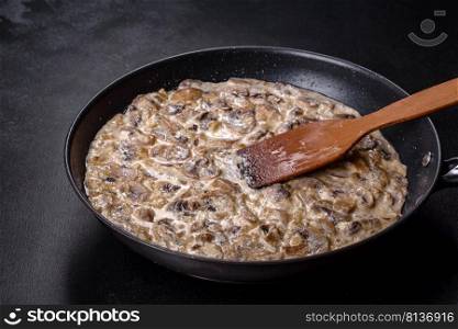 Delicious fresh young ch&ignons sliced into slices in creamy sauce simmered in a black pan. Delicious fresh young ch&ignons sliced into slices in creamy sauce